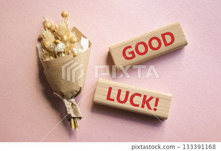 Good luck symbol. Wooden blocks with words Good luck. Beautiful pink background with bouquet of flowers. Business and Good luck concept. Copy space. 133391168