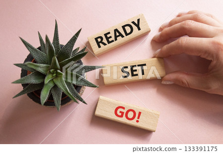 Ready Set Go symbol. Concept words Ready Set Go on wooden blocks. Beautiful pink background with succulent plant. Businessman hand. Business and Ready Set Go concept. Copy space. 133391175