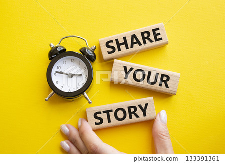 Share your story symbol. Wooden blocks with words Share your story. Businessman hand. Beautiful yellow background with alarm clock. Business and Share your story concept. Copy space. Share your story symbol. Wooden blocks with words Share your story. Businessman hand. Beautiful yellow background with alarm clock. Business and Share your story concept. Copy space. 133391361