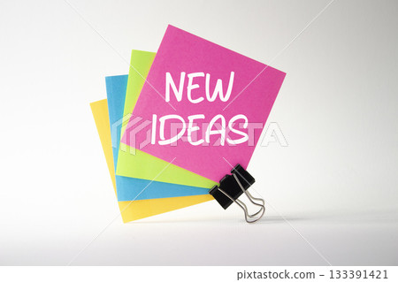 New ideas symbol. Pink sticky note with concept words New Ideas. Beautiful white background. Business and New ideas concept. Copy space New ideas symbol. Pink sticky note with concept words New Ideas. Beautiful white background. Business and New ideas concept. Copy space 133391421