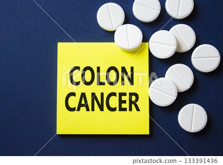 Colon Cancer symbol. Concept word Colon Cancer on yellow note. Beautiful deep blue background with pills. Medicine and Colon Cancer concept. Copy space 133391436