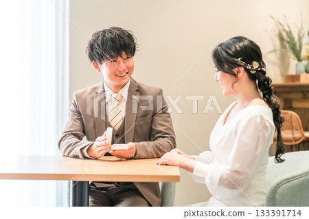 一名男子在餐廳向女子求婚,女子收到一枚戒指。 一名男子在餐廳向女子求婚,女子收到一枚戒指。 133391714