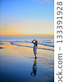 She looks at the sunset sea 133391928
