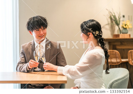 A couple in a dress code having a conversation while drinking champagne at a restaurant or bar 133392554