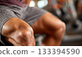 Close up of a persons knee during intense workout at gym showing muscular definition and focus 133394590