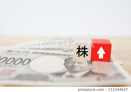 Image of the Japanese yen and an upward arrow indicating rising stock prices. 133394647