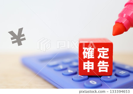 Red block showing tax return. Calculator and red pen. 133394653