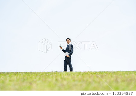 Businessman walking with smartphone in the sky Businessman walking with smartphone in the sky 133394857