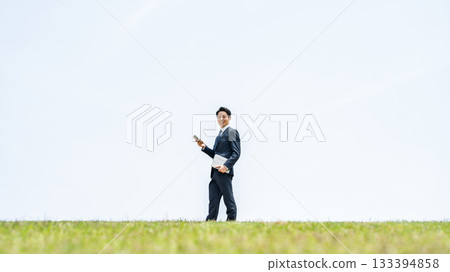 Businessman walking with smartphone in the sky 133394858