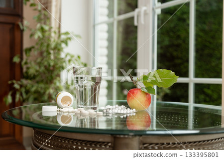 Healthy Lifestyle Concept Apple, Pills and Water Representing Balance Healthy Lifestyle Concept Apple, Pills and Water Representing Balance 133395801