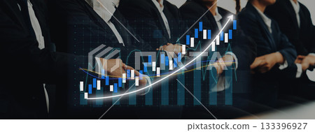 Business professionals in suits analyzing stock market trends, with a graphical representation of rising data charts illustrating growth in financial investments. Axiom 133396927