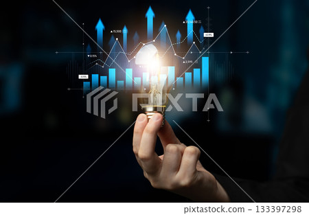 Light Bulb in Hand Overlapping Digital Graphs with Upward Trend Indicating Innovation, Bright Ideas, Growth and Business Strategy in Modern Concept Scalp 133397298