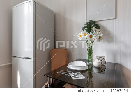 Bright Kitchen Corner with Refrigerator and Glass Table Bright Kitchen Corner with Refrigerator and Glass Table 133397494