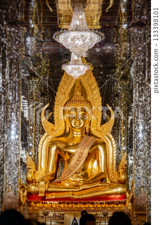 Inside the glass temple at Wat Tha Sung, Uthai Thani Province, Thailand, the room is illuminated with dazzling light, with a golden Buddha image at its center. 133398101