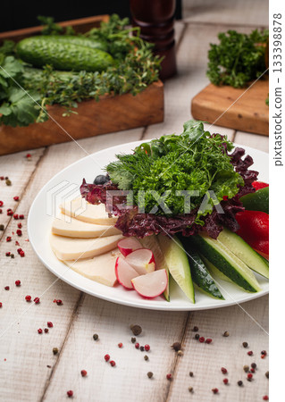 Fresh vegetable plate with greens and cheese 133398878