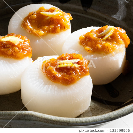 Four steamed daikon radishes on a plate 133399966