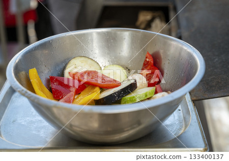 Mix of fresh vegetables in a stainless steel bowl on scales 133400137