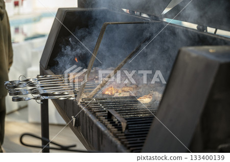 cooking meat on grill at barbecue party in summer garden. 133400139