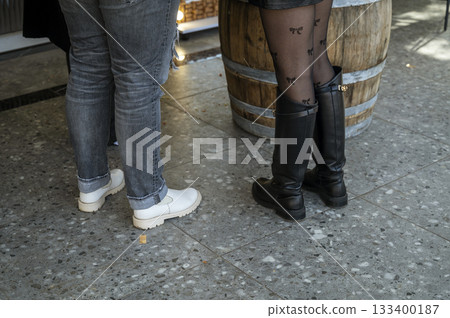 Two pairs of women's legs in autumn or spring close-up. 133400187