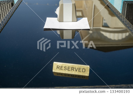 A simple "reserved" sign on a dark table in a poolside restaurant A simple "reserved" sign on a dark table in a poolside restaurant 133400193
