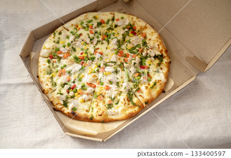 Delicious pizza with mozzarella, chicken, pepper, corn and green peas and carrots 133400597