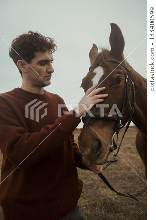 Loving tender moment between men and horse.Young smiling man and horse. 133400599