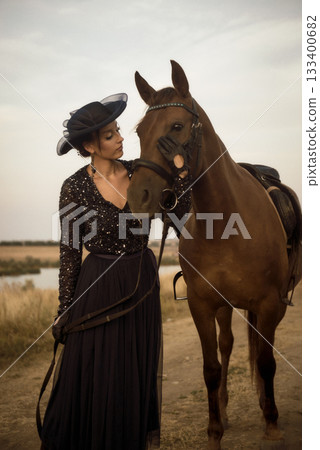 beautiful equestrian woman is walking with horse after horse riding 133400682