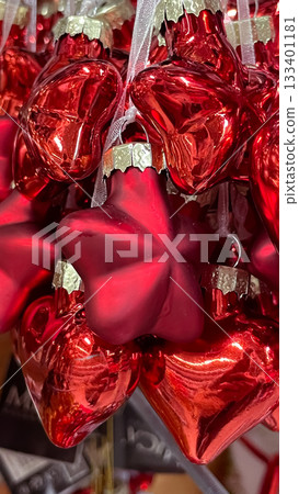 Vibrant red Christmas ornaments in heart and star shapes, hanging together. Close-up 133401181