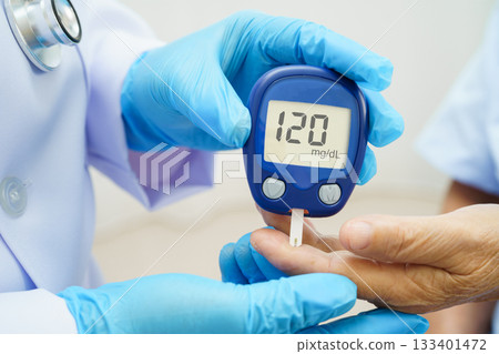 Asian doctor using digital glucose meter for check sample blood sugar level to treatment diabetes. Asian doctor using digital glucose meter for check sample blood sugar level to treatment diabetes. 133401472