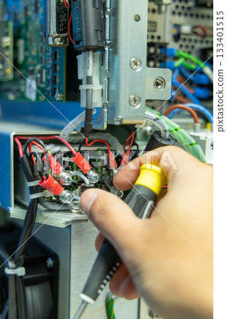 Man's hand repairing an electronic board 133401515