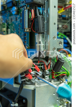 Man's hand repairing an electronic board 133401517