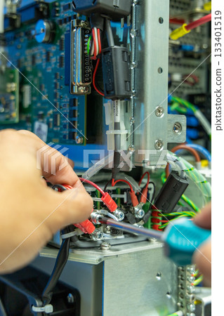 Man's hand repairing an electronic board 133401519