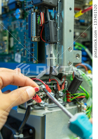 Man's hand repairing an electronic board 133401520