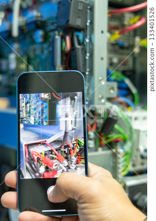 Man's hand repairing an electronic board 133401526
