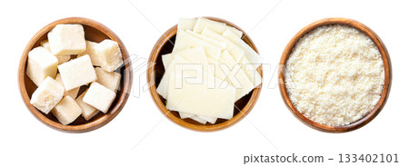 Grana Padano cheese, Italian hard cheese, in wooden bowls. Block shaped chunks, thin slices, and grated cheese, similar to Parmesan, with crumbly and slightly gritty texture, and strong savory flavor. Grana Padano cheese, Italian hard cheese, in wooden bowls. Block shaped chunks, thin slices, and grated cheese, similar to Parmesan, with crumbly and slightly gritty texture, and strong savory flavor. 133402101