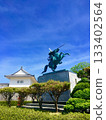 A castle and a statue of a mounted warrior against the blue sky 133402564