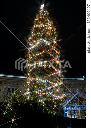 large Christmas tree with garlands and a star on top in the town square. large Christmas tree with garlands and a star on top in the town square. 133404407