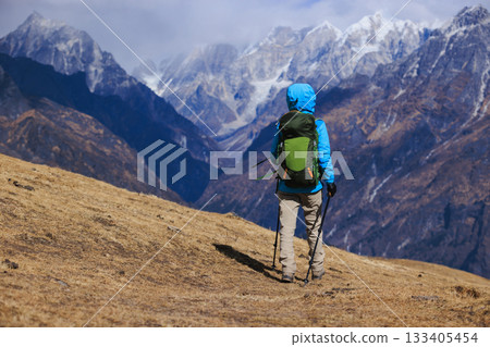 Backpacking woman hiking on high altitude mountain top Backpacking woman hiking on high altitude mountain top 133405454