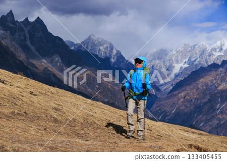 Backpacking woman hiking on high altitude mountain top 133405455