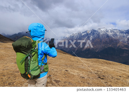 Backpacking woman hiking on high altitude mountain top Backpacking woman hiking on high altitude mountain top 133405463