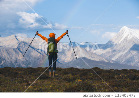 Backpacking woman hiking on sunset high altitude mountain top Backpacking woman hiking on sunset high altitude mountain top 133405472