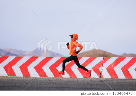 Fitness woman trail runner running on trail leading to Mount Everest in tibet, China 133405473