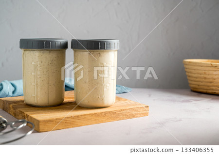 Sourdough starter in glass jars, bright background, copy space 133406355