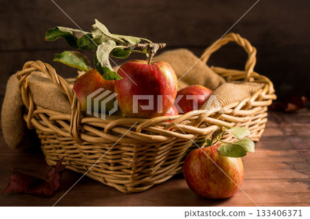 Freshly picked red apples in a basket, rustic wooden background 133406371