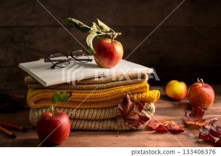 Autumn rustic background. A notebook with apples, leaves and knitted blankets. Dark, moody style 133406376