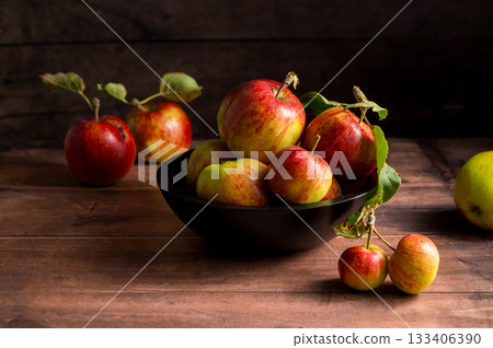 Freshly picked red apples in a bowl, rustic wooden background 133406390
