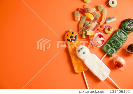 Halloween candies over orange background, eye balls, warms, pumpkins. Flat lay, copy space Halloween candies over orange background, eye balls, warms, pumpkins. Flat lay, copy space 133406393