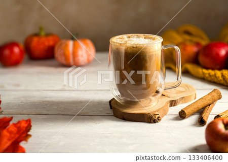 Cosy autumn coffee drink, with apples and cinnamon, orange pumpkins, wooden rustic background Cosy autumn coffee drink, with apples and cinnamon, orange pumpkins, wooden rustic background 133406400
