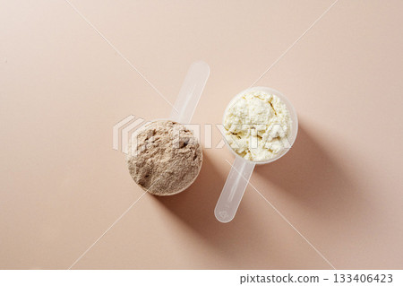 Protein powder. Chocolate and vanilla flavoured protein powder in scoops, top view 133406423