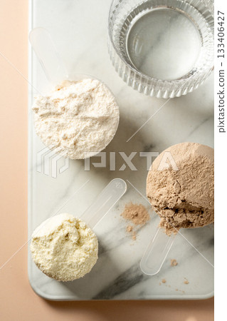 Protein powder in scoops. Different flavours of whey protein powders, top view 133406427